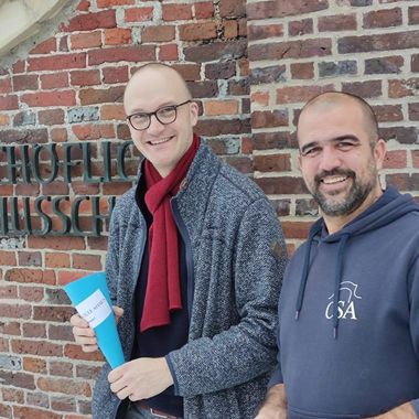 Links der neue Kollege Hendrik Drüing mit Schultüte, rechts Schulleiter Hakenes.